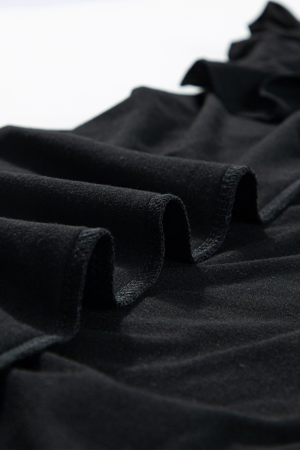 Crni kombinezon širokih nogavica s podesivim čvorovima na naramenice