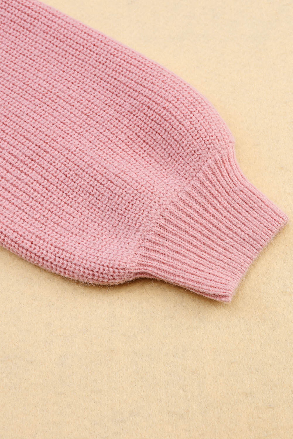 Ružičasti pleteni pulover s V izrezom i spuštenim ramenima