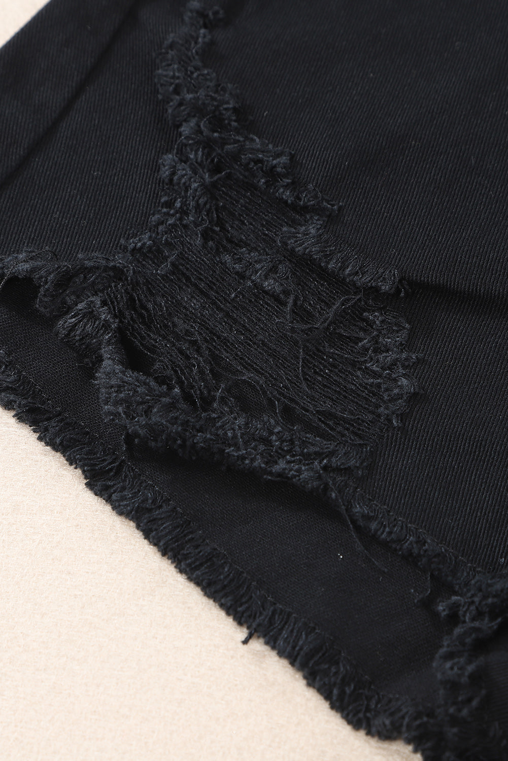 Crne asimetrične kratke hlače od poderanog trapera