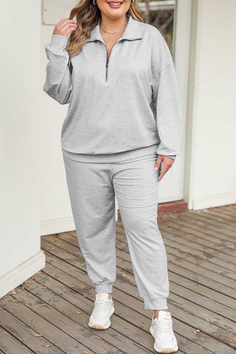 Sivi pulover s patentnim zatvaračem i odjeća za trčanje veće veličine