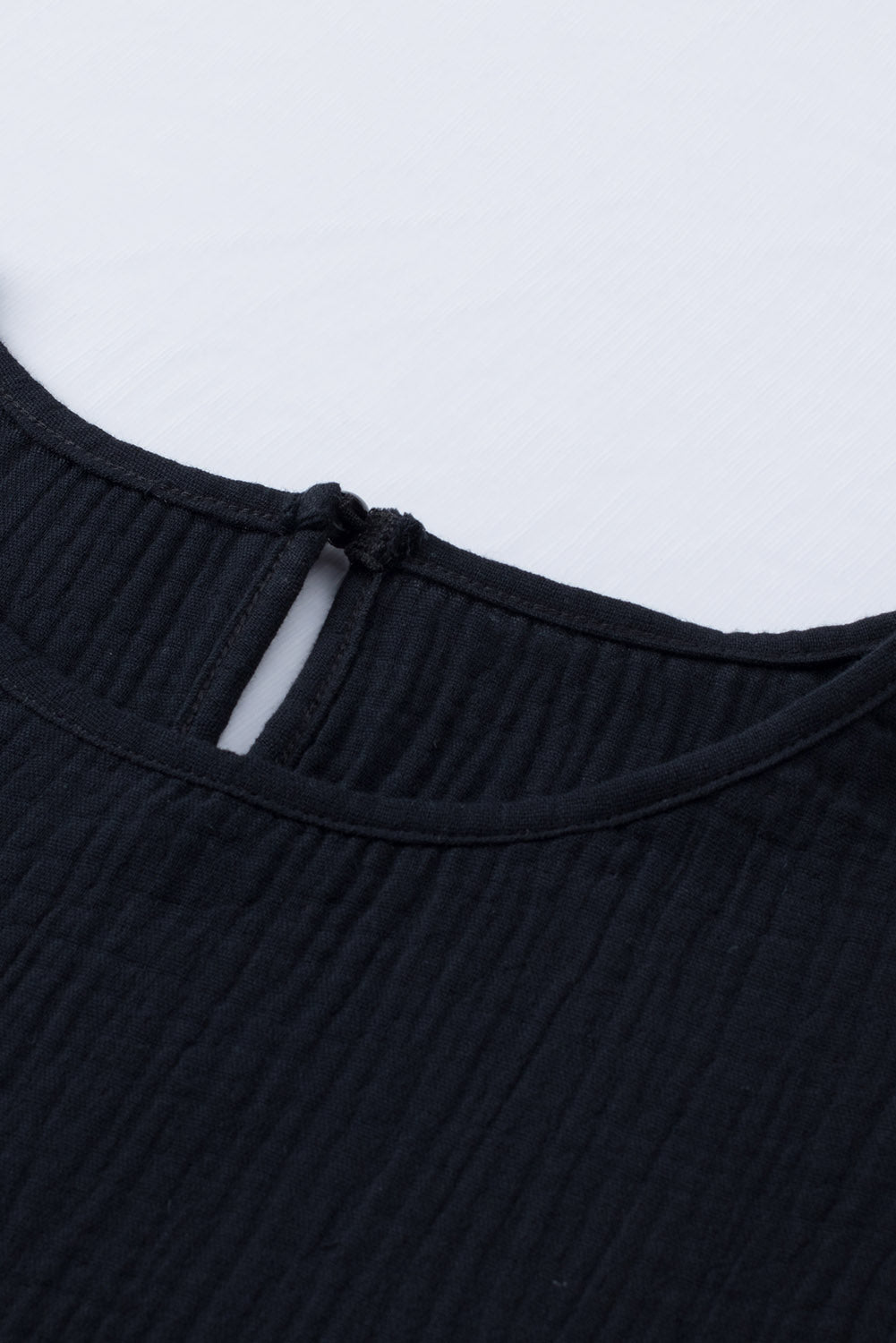 Črna teksturirana bluza s kratkimi rokavi v več stopnjah