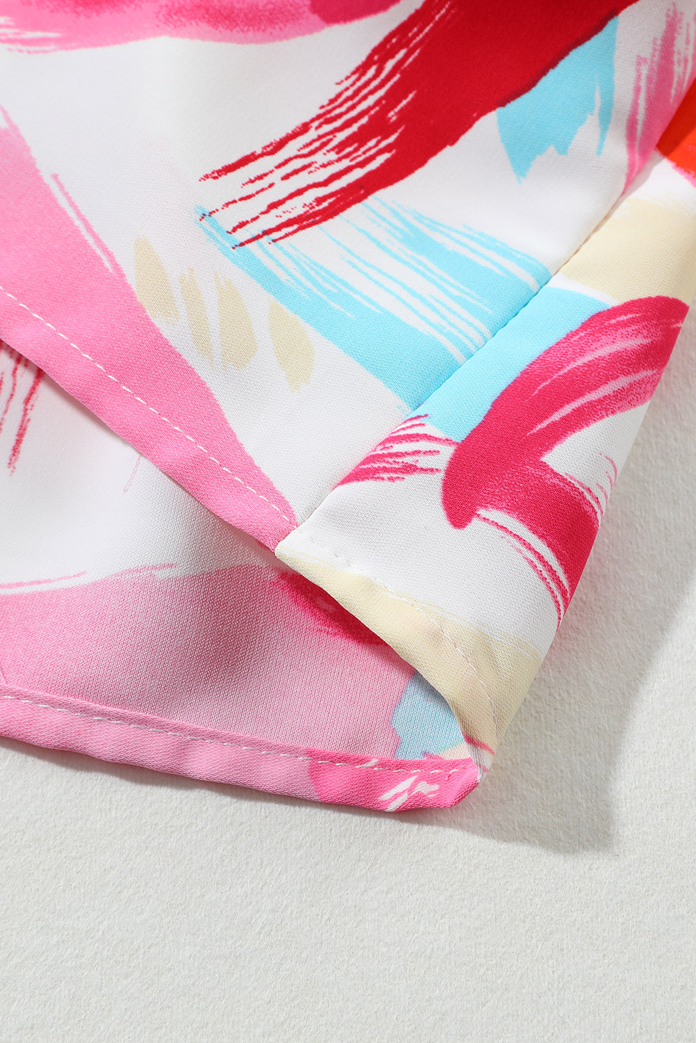 Rožnata majica z napihnjenimi rokavi in ​​peplum z abstraktnim potiskom