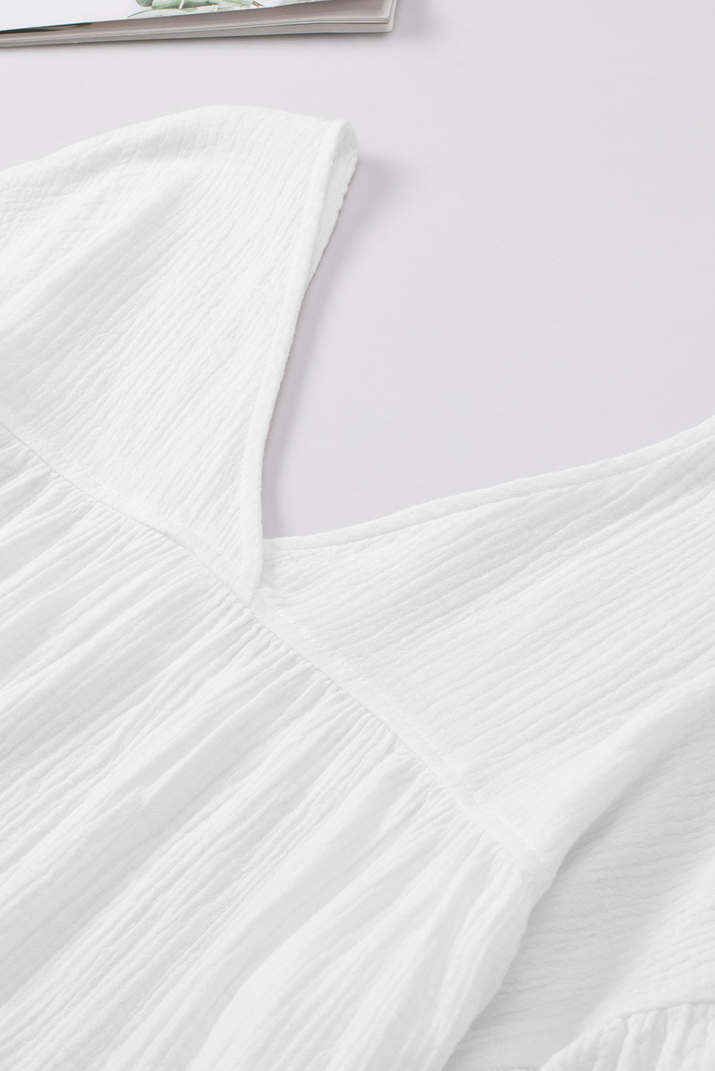 Weiße strukturierte Babydoll-Bluse mit V-Ausschnitt und Armbandärmeln
