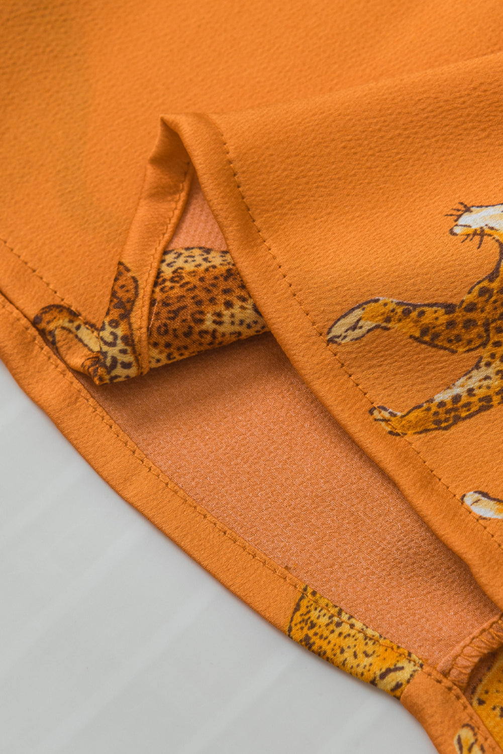 Orangefarbene Bluse mit Gepardenmuster und Rüschenärmeln