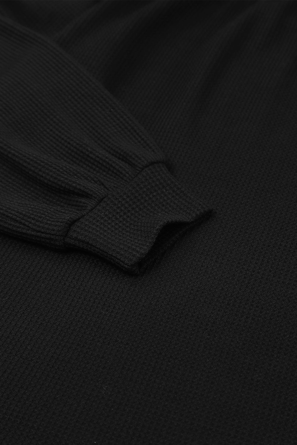 Haut noir en tricot gaufré à manches bouffantes et encolure dégagée