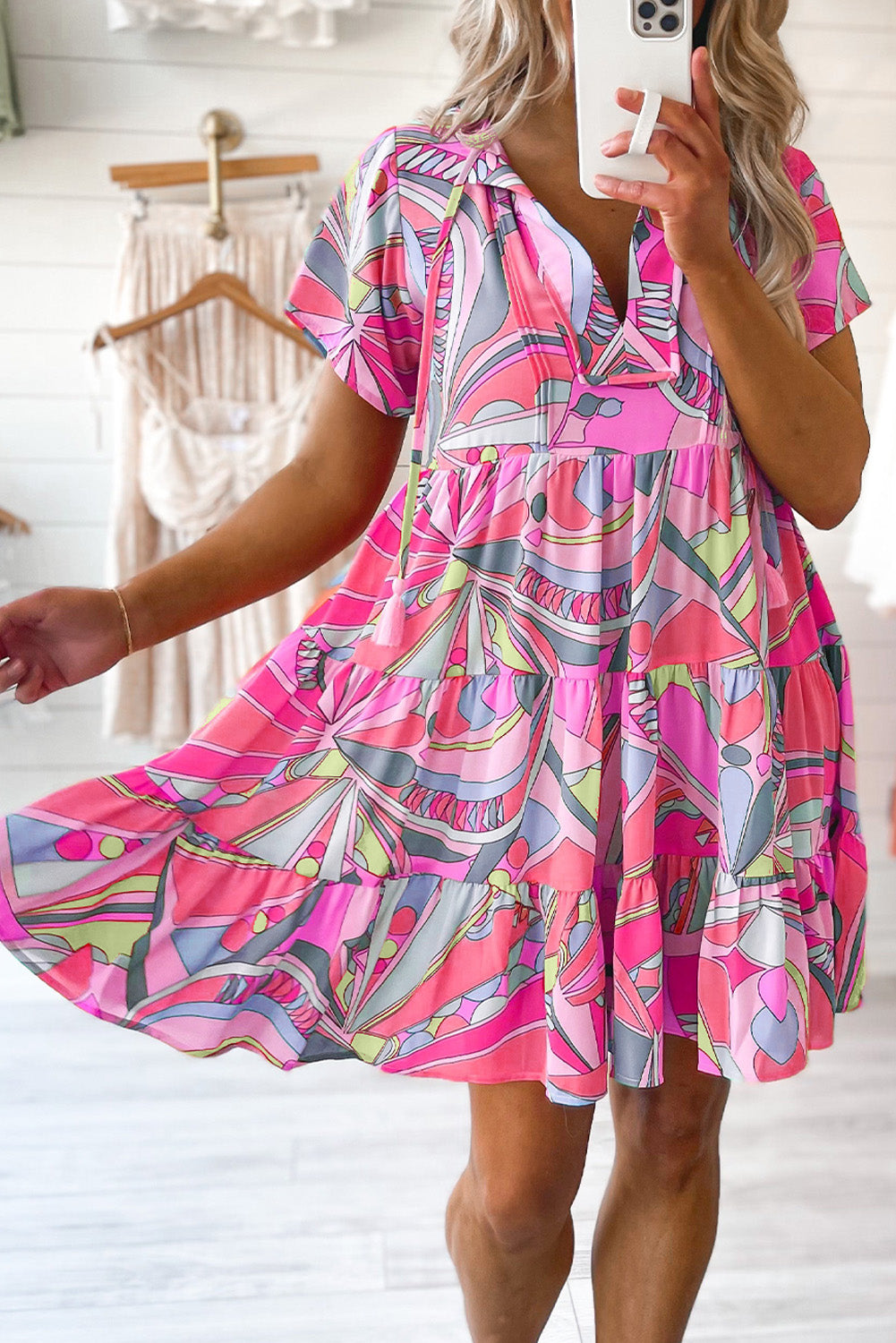 Rožnata, široka obleka z abstraktnim geometrijskim vzorcem in resicami