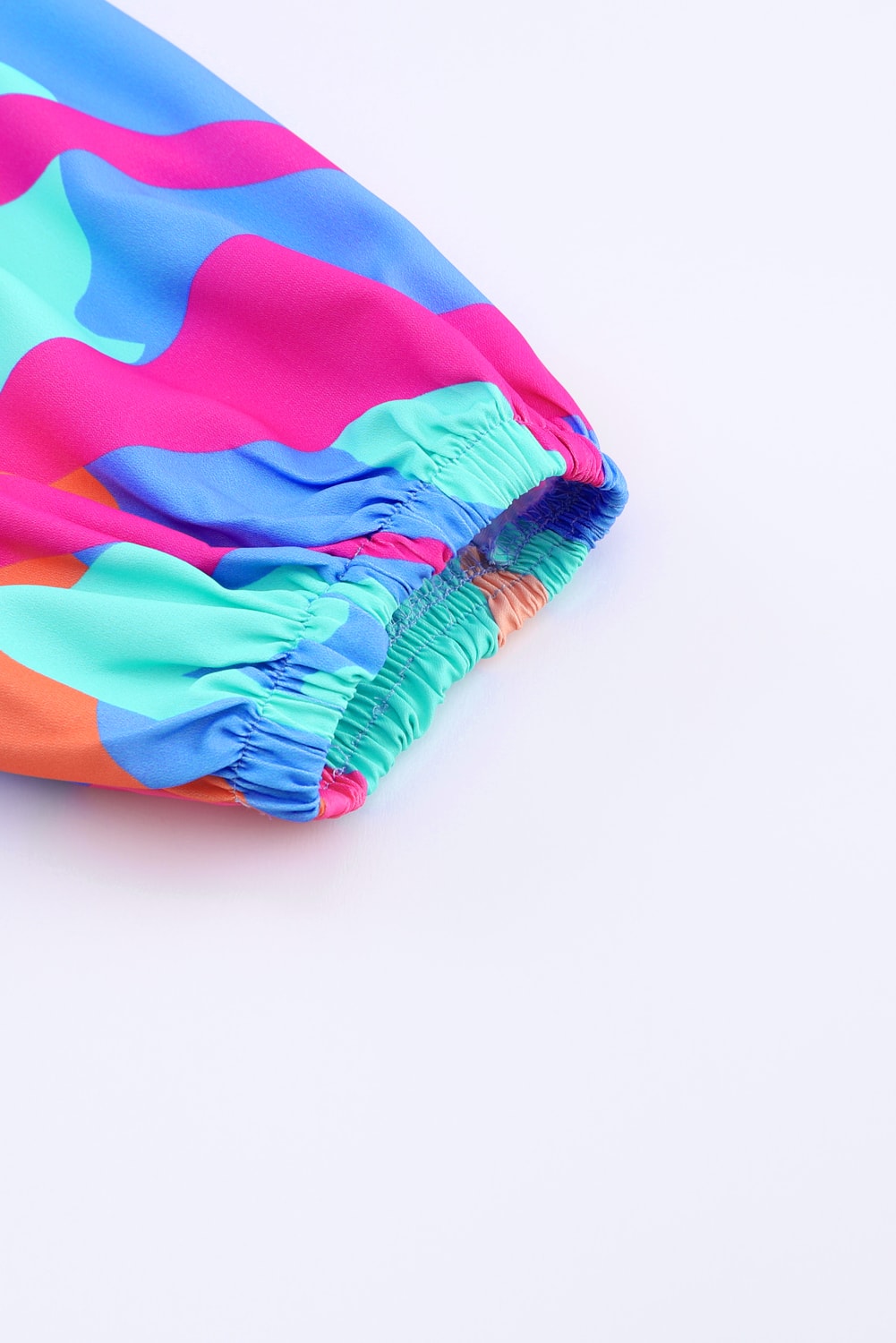 Obleka z večbarvnim abstraktnim potiskom in v-izrezom z napihnjenimi rokavi