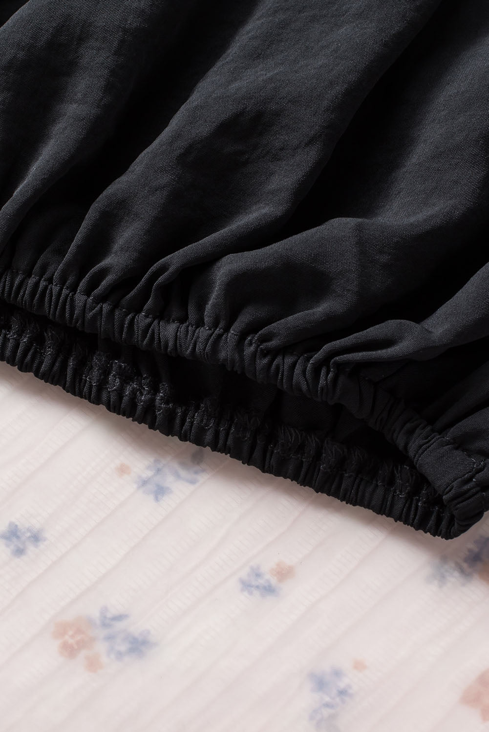 Črna podložena ohlapna bluza z manšetami in naborki na ramenih