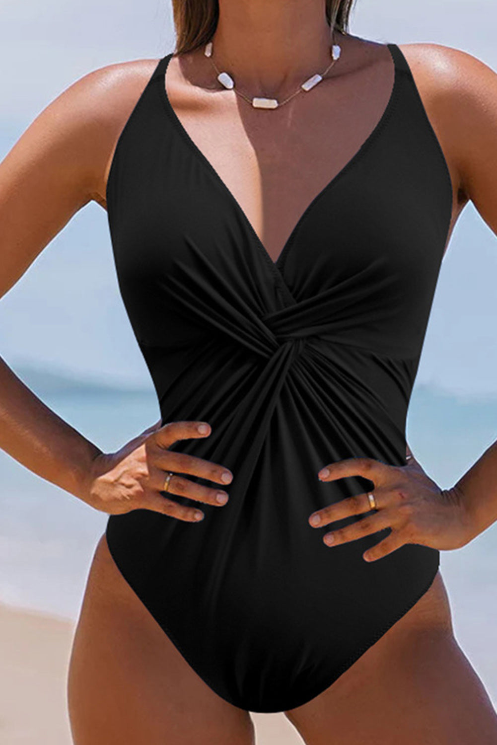 Crni jednodijelni kupaći kostim s V izrezom i ukrštenim naborima bez leđa
