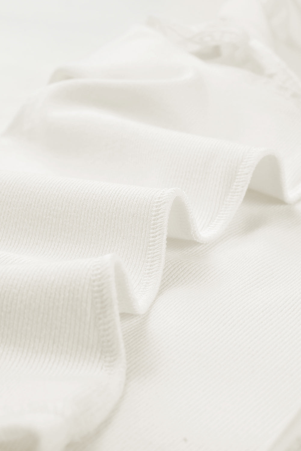 Bela rebrasta pletena majica z v-izrezom in plapolami na ramenih
