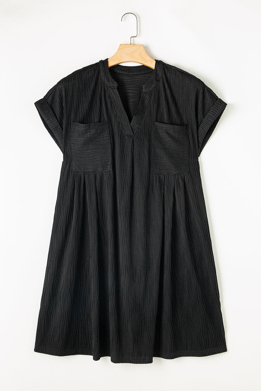 Mini-robe noire texturée à col en V et manches courtes avec poches