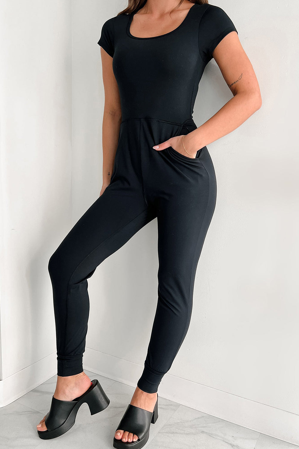 Schwarzer Athleisure-Jumpsuit mit kurzen Ärmeln und Tasche und Jogger-Unterteil