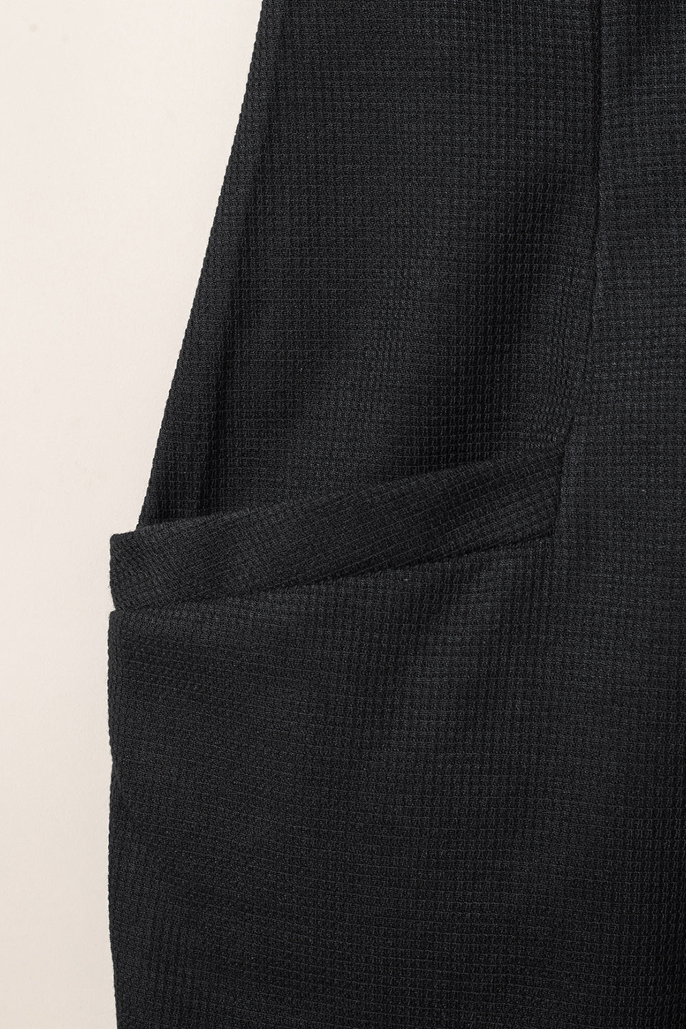 Črn teksturiran kombinezon brez rokavov z žepi in v-izrezom