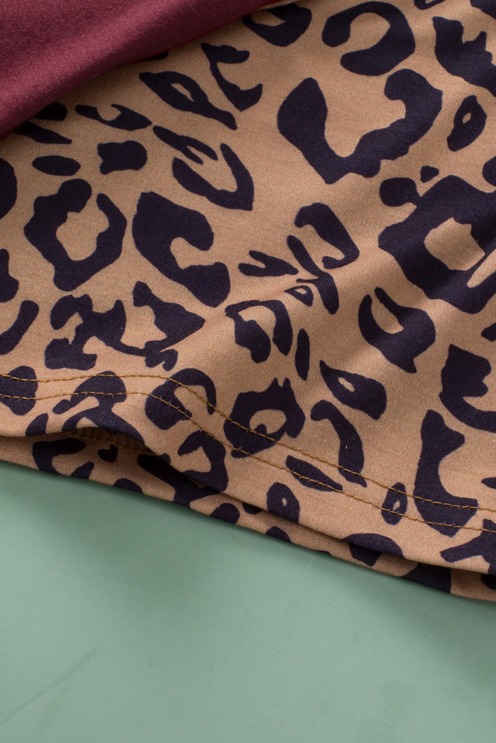 Burgunderfarbenes Plus-Size-T-Shirt mit Raglanärmeln und kontrastierendem Leopardenmuster