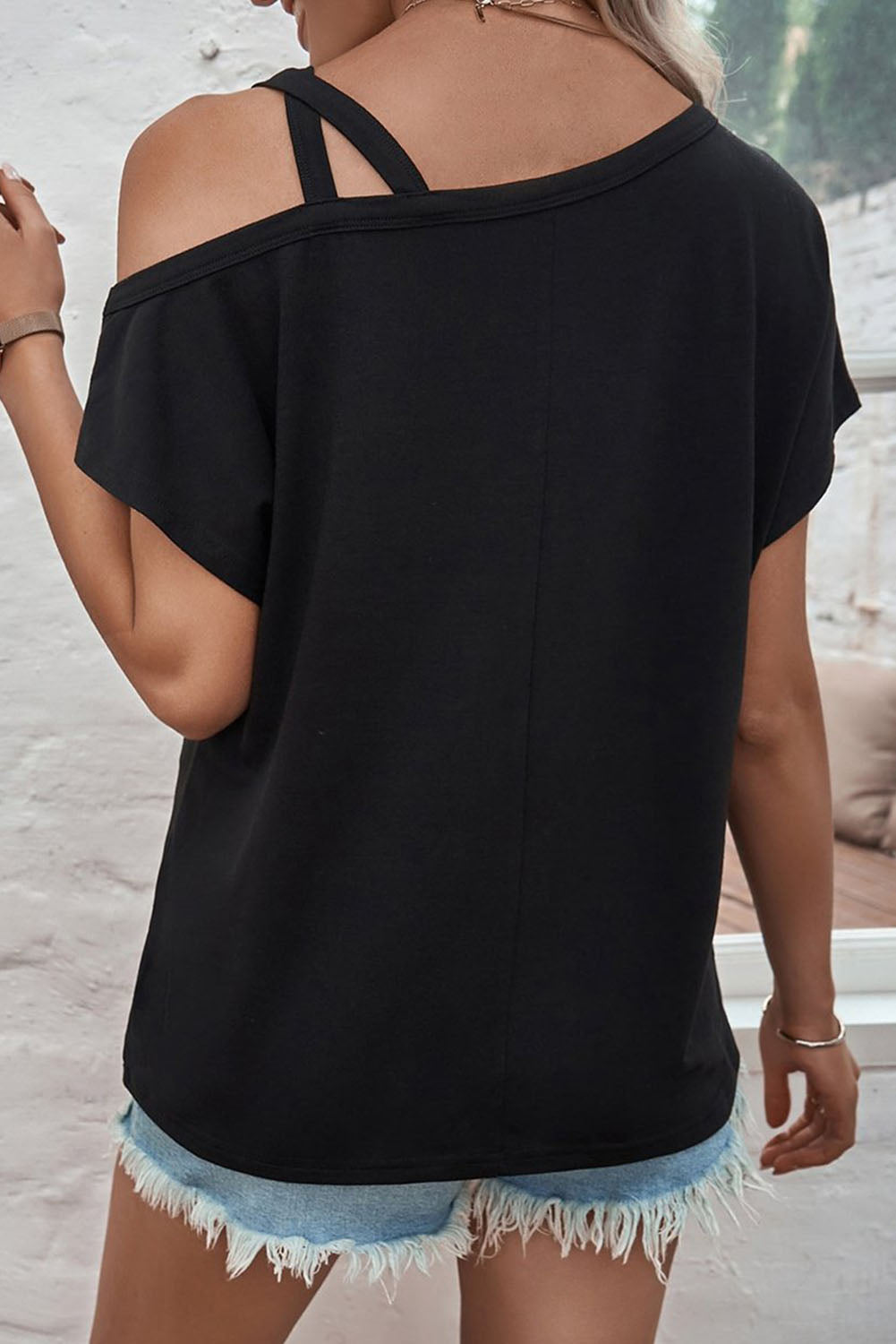 T-shirt nera asimmetrica incrociata su una spalla