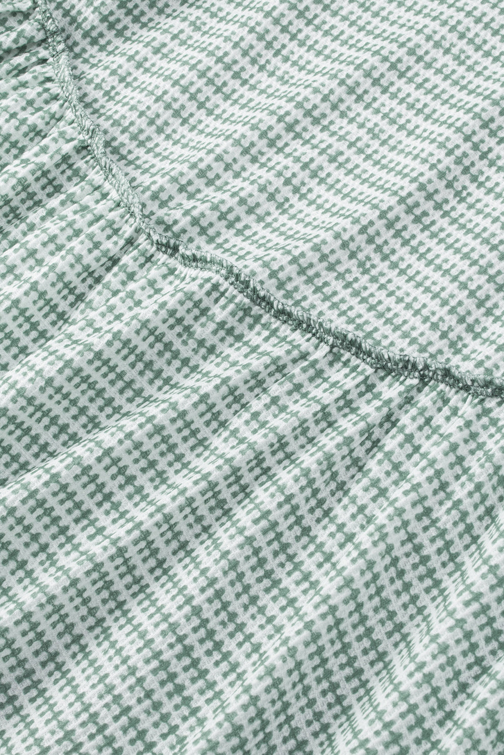 Travnato zelena majica z izpostavljenimi šivi in ​​pleteninami z naborki