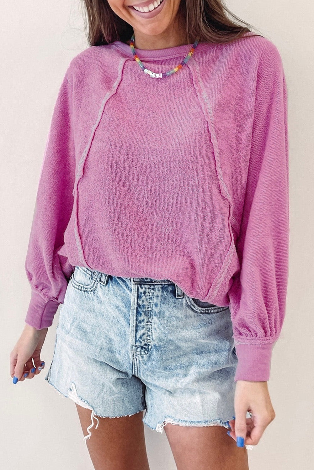 Ružičasti pulover od frotira s otkrivenim šavovima s okruglim izrezom