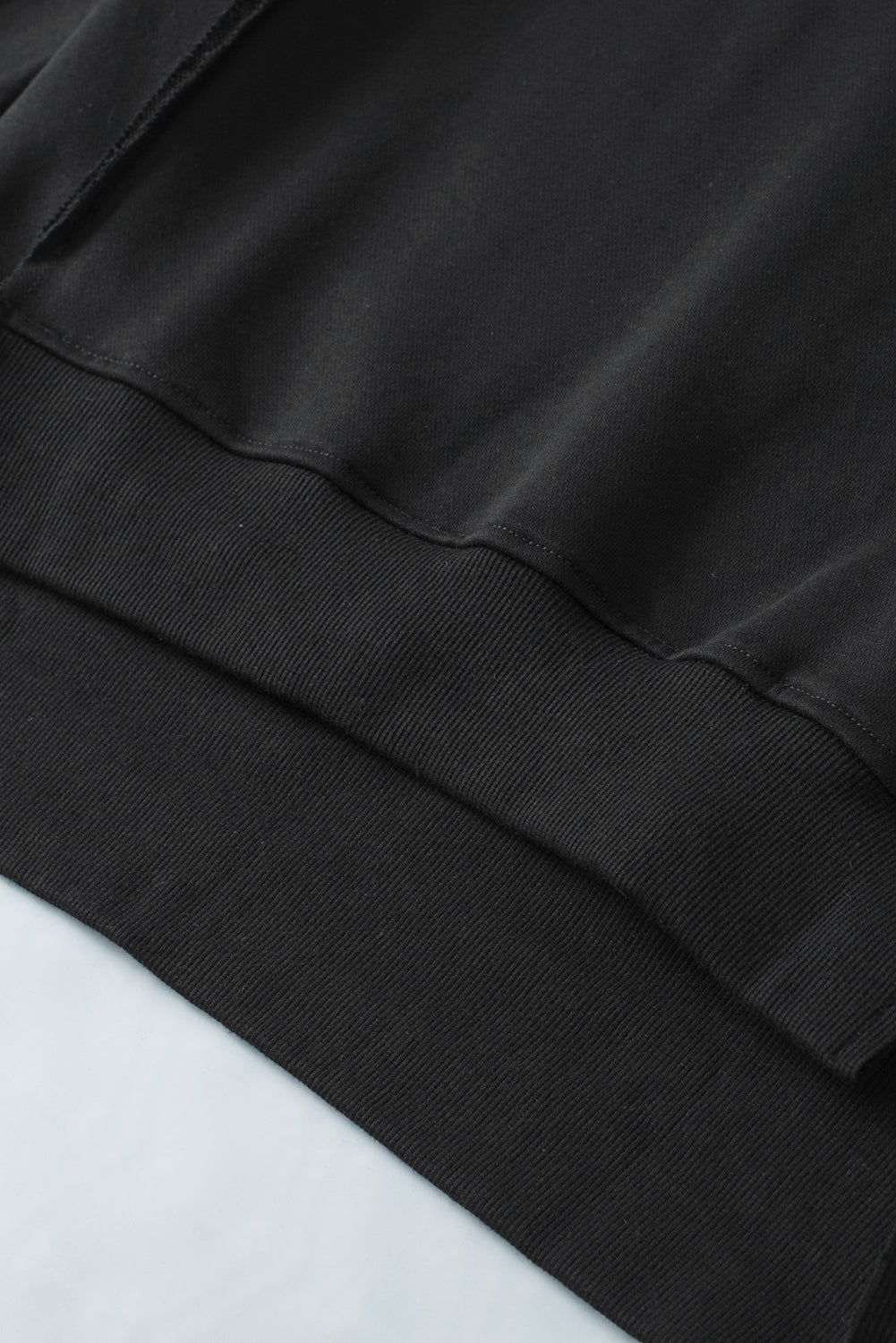Crna majica s otvorenim šavovima s prorezima na ramenima i visokim niskim porubom