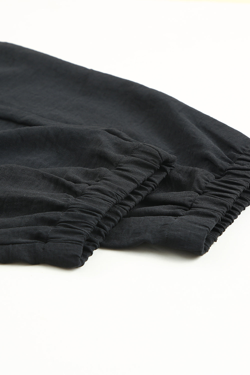Pantalon de jogging noir à taille smockée avec cordon de serrage de couleur unie