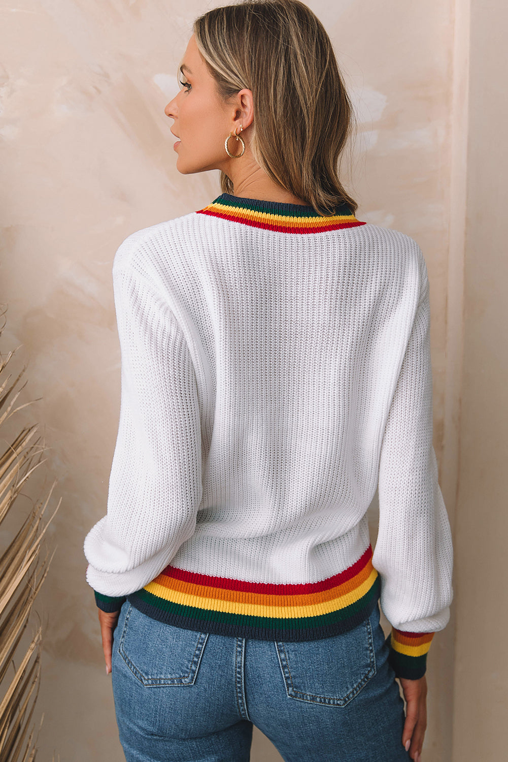 Weißer Pullover mit fröhlichen und leuchtend bunten Streifenbesatz