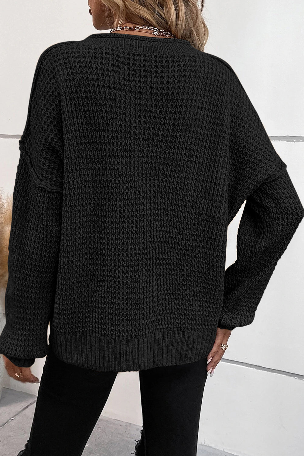 Schwarzer Pullover aus Pointelle-Strick mit Knöpfen, V-Ausschnitt und überschnittener Schulter