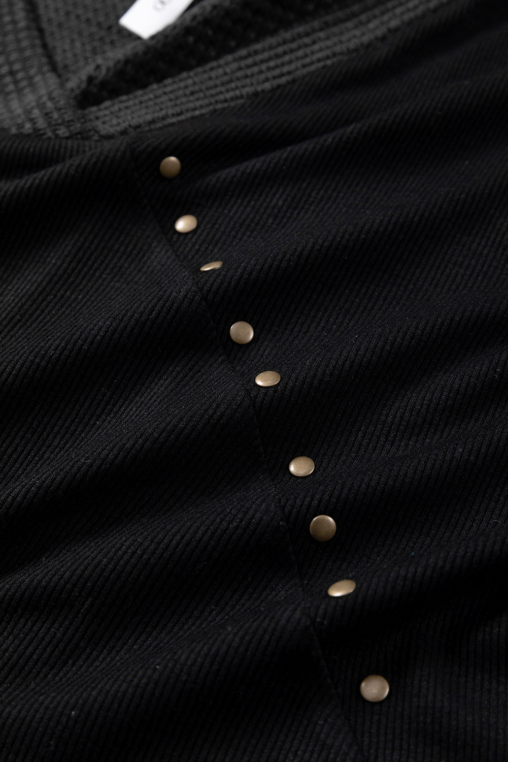 Camicetta borchiata con scollo a V e cuciture in maglia nera a contrasto
