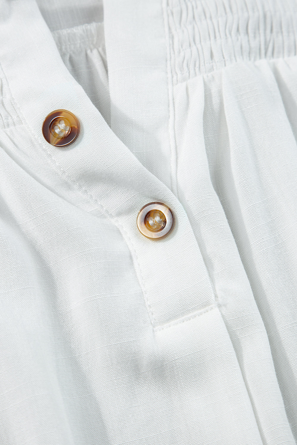 Majica brez rokavov z belimi gumbi in razcepljenim ovratnikom