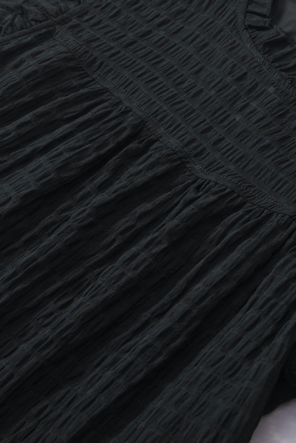 Schwarze Bluse mit ausgehöhlter Struktur und Rüschenärmeln