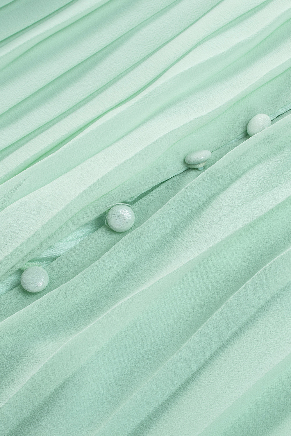 Zeleni plisirani kombinezon s v-izrezom i dugmadima za vezanje