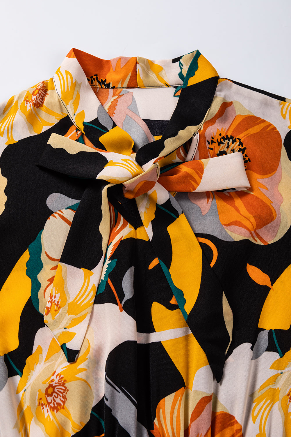 Oranžna obleka z dolgimi rokavi in ​​zavezujočim izrezom s cvetličnim vzorcem