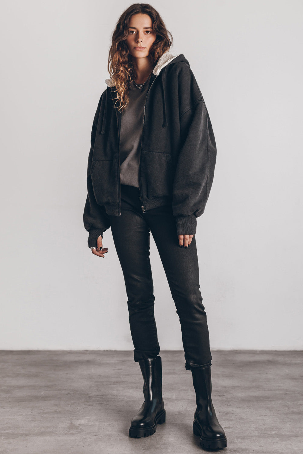Veste zippée à capuche noire en sherpa avec manches passe-pouces