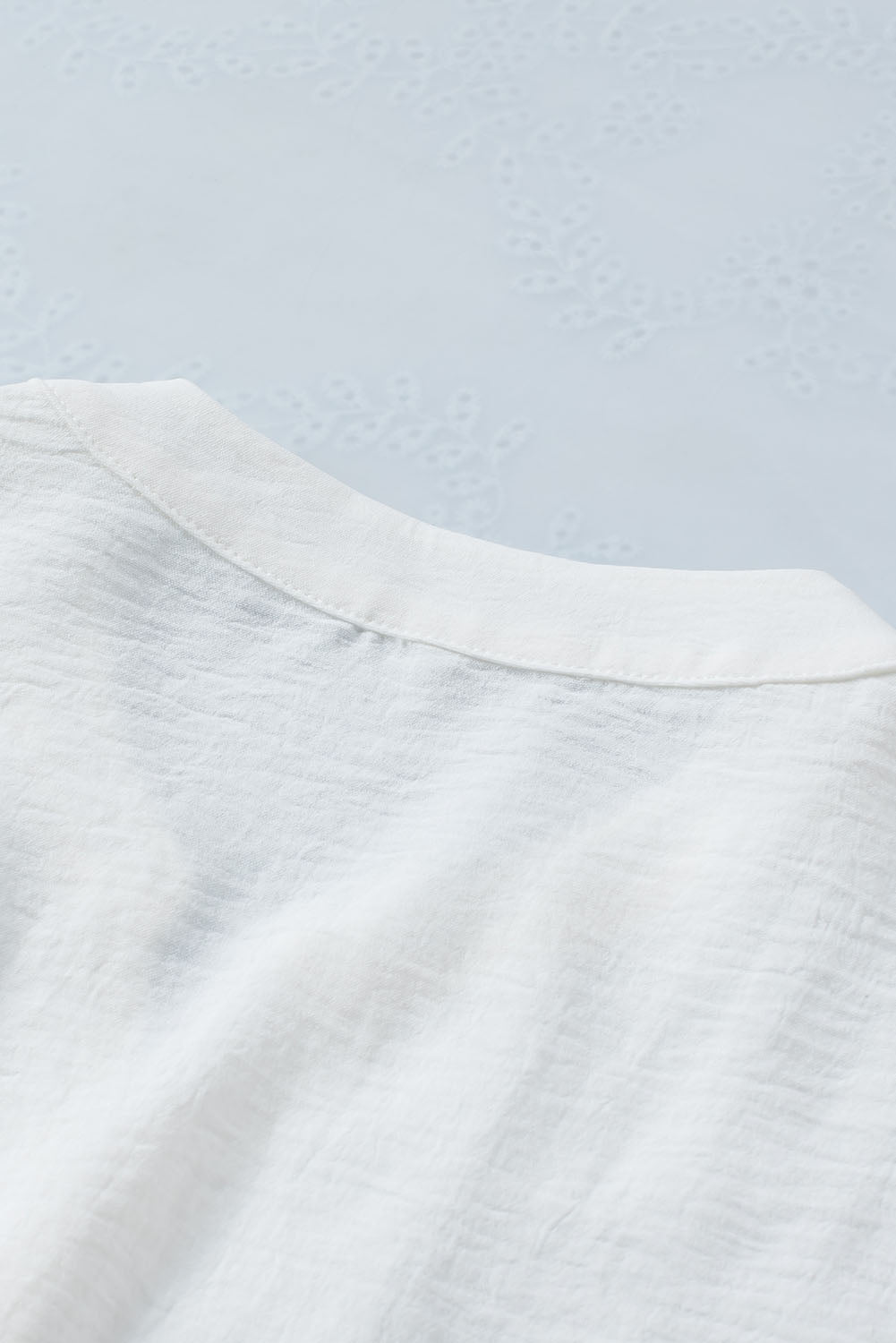 Chemise blanche sans manches à col fendu et cordon de serrage à la taille
