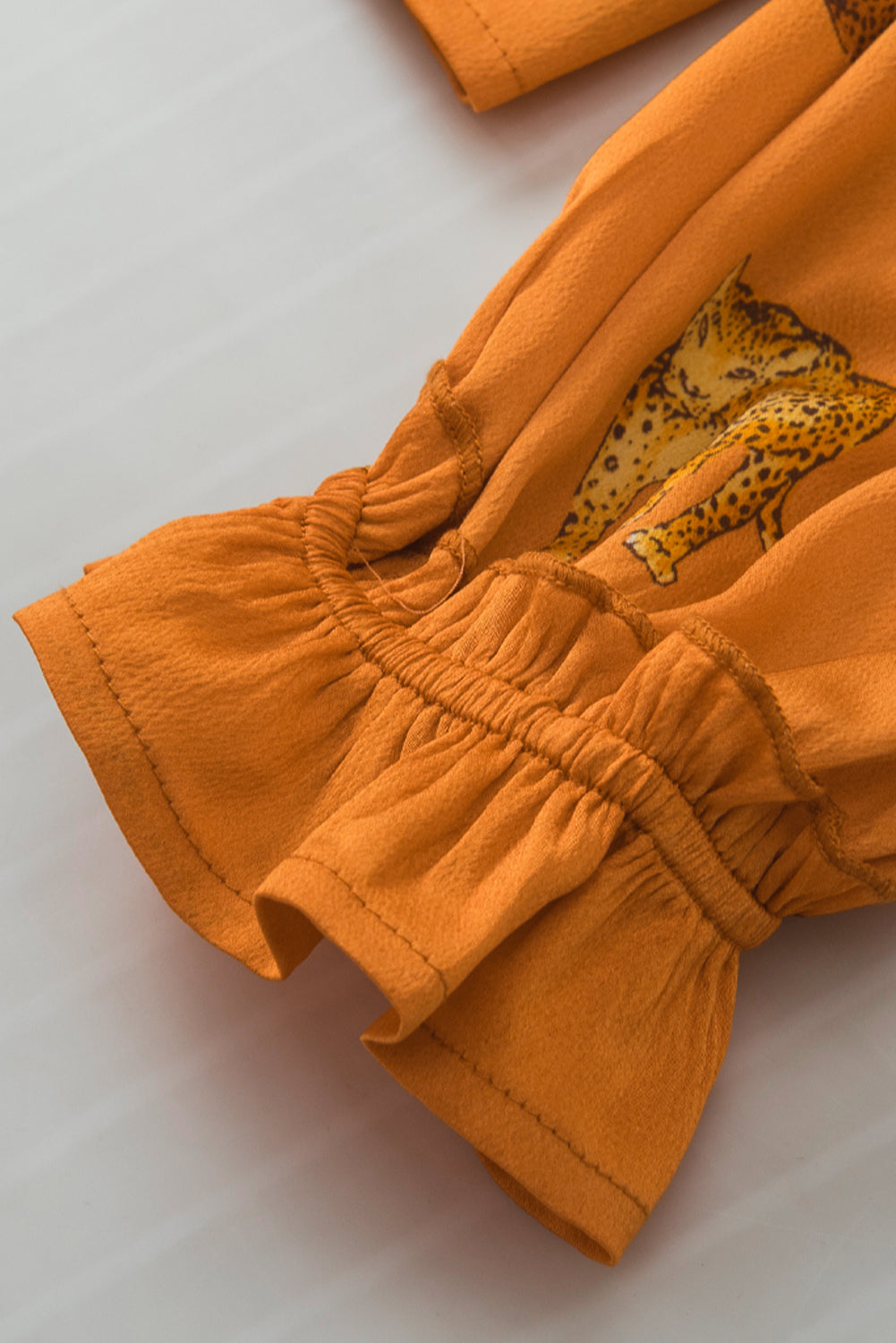 Oranžna bluza z naborkanimi rokavi in ​​potiskom geparda