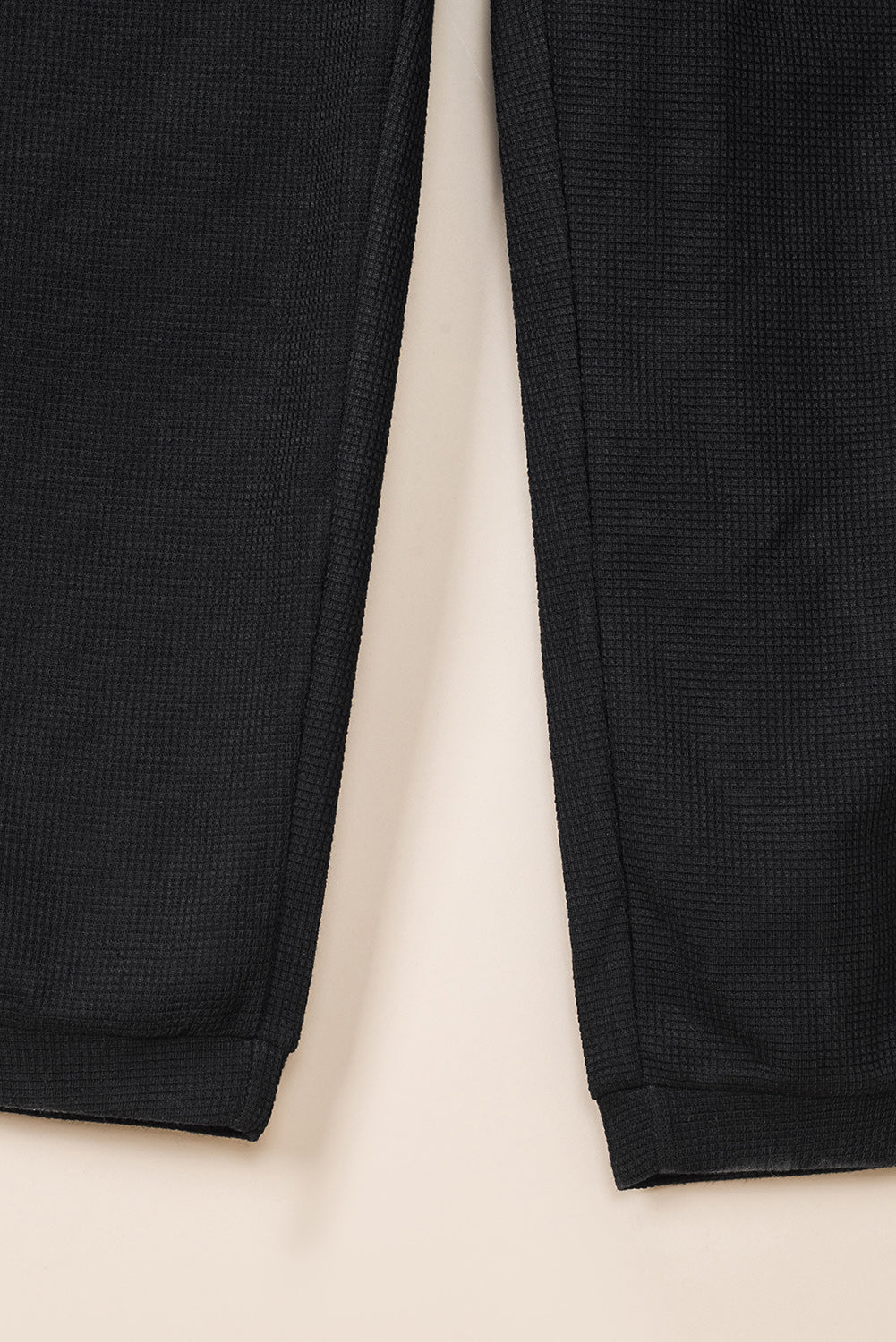 Črn teksturiran kombinezon brez rokavov z žepi in v-izrezom