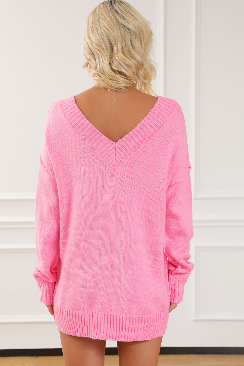Rožnat pulover z razkritim šivom v izrezu
