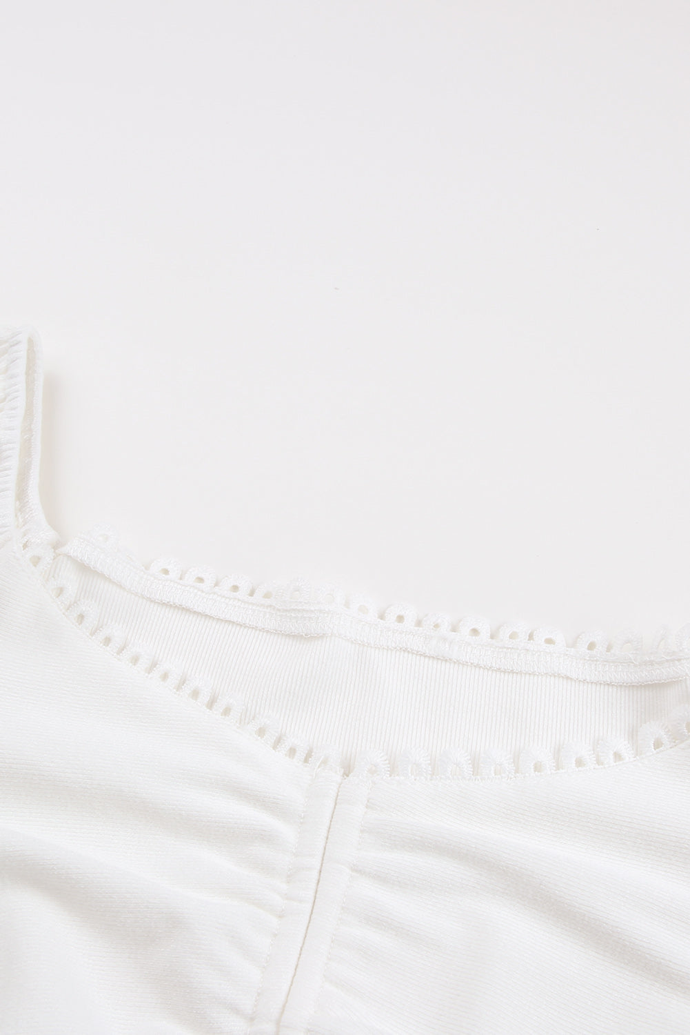 Kratka majica z belo vrvico, ki se nagne čez ramena