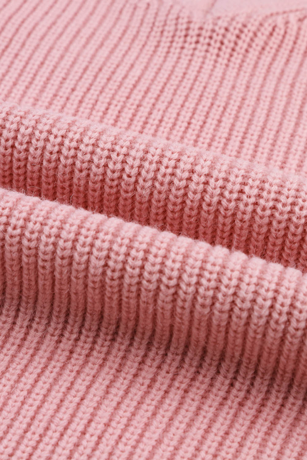 Rožnat pleten pulover z v-izrezom in spuščenimi rameni