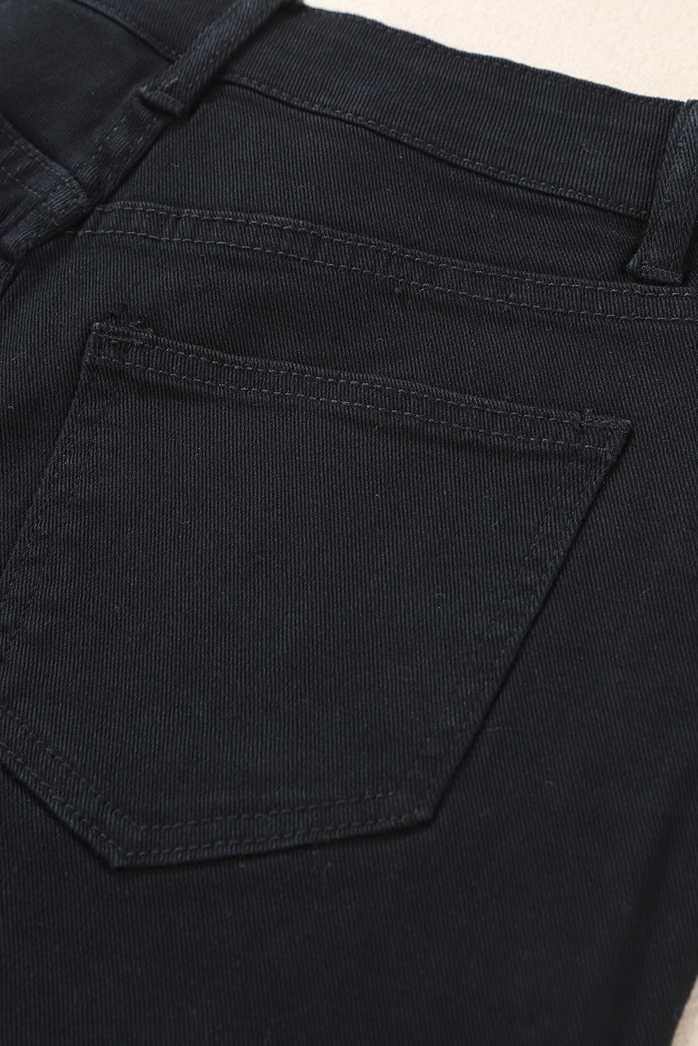 Črne asimetrične kratke hlače iz raztrganega jeansa