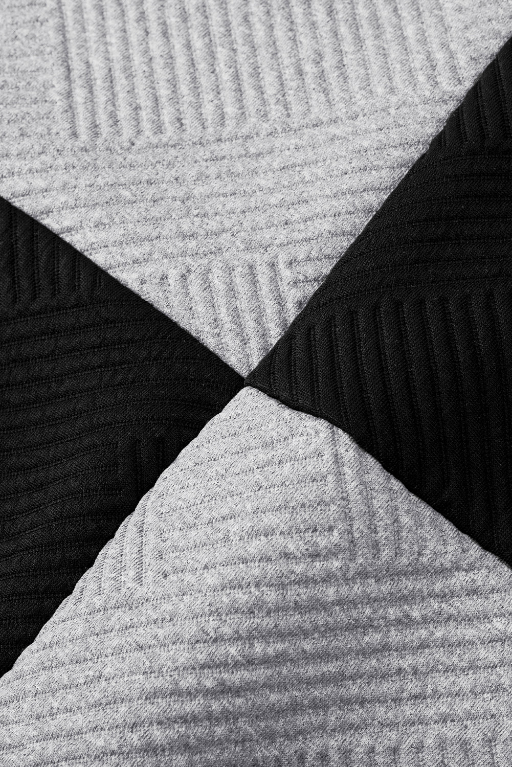 Schwarzes, strukturiertes Oberteil mit überschnittener Schulterpartie im Farbblockdesign