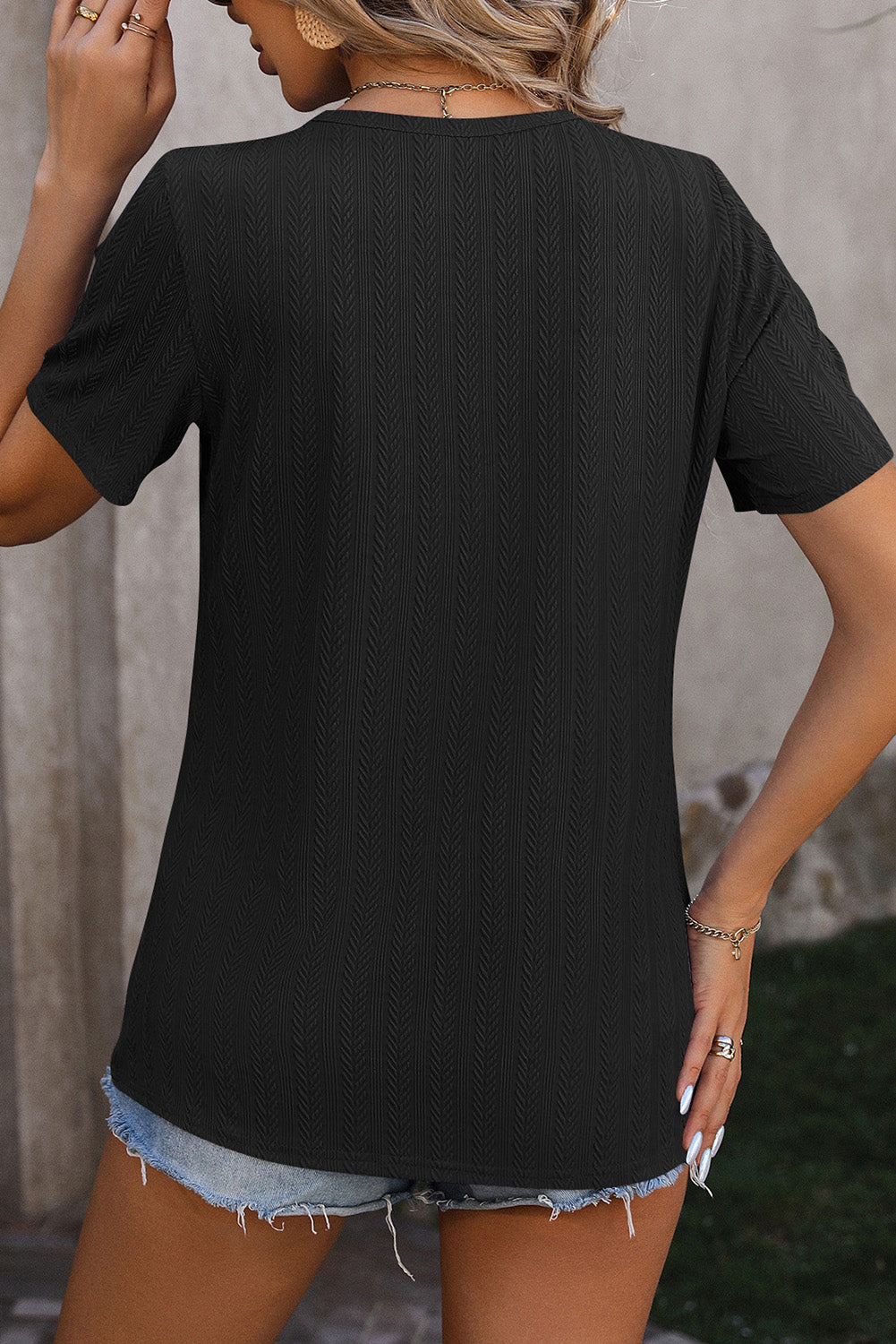 Schwarzes, strukturiertes T-Shirt mit Knöpfen und Schlitzdetail