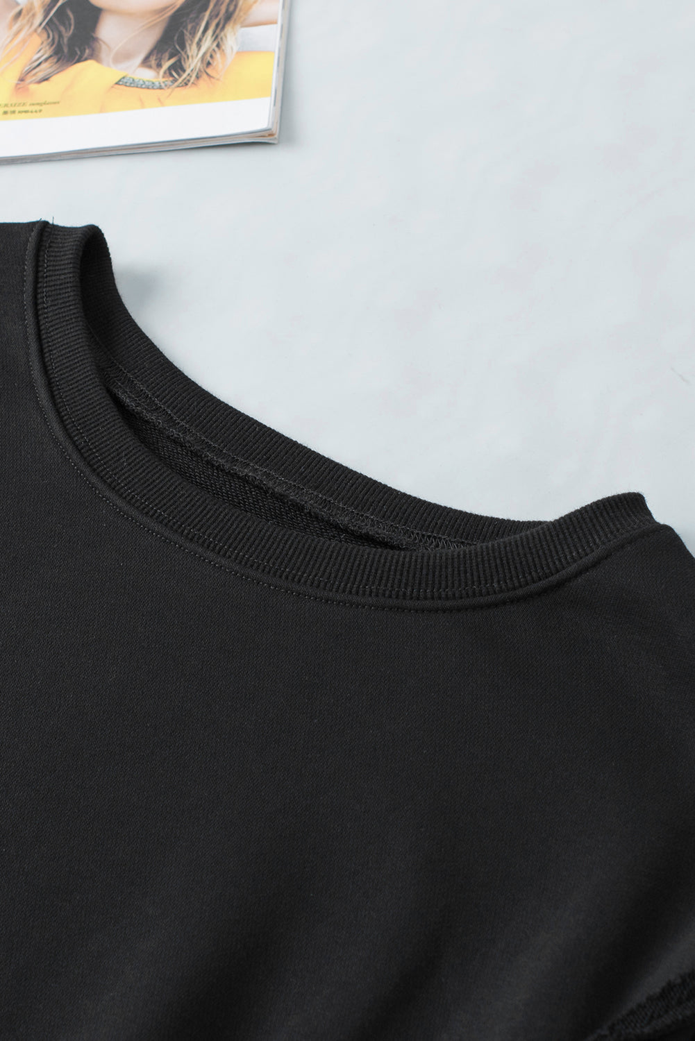 Schwarzes Sweatshirt mit freiliegender Naht und überschnittener Schulter, Schlitz und hohem Saum