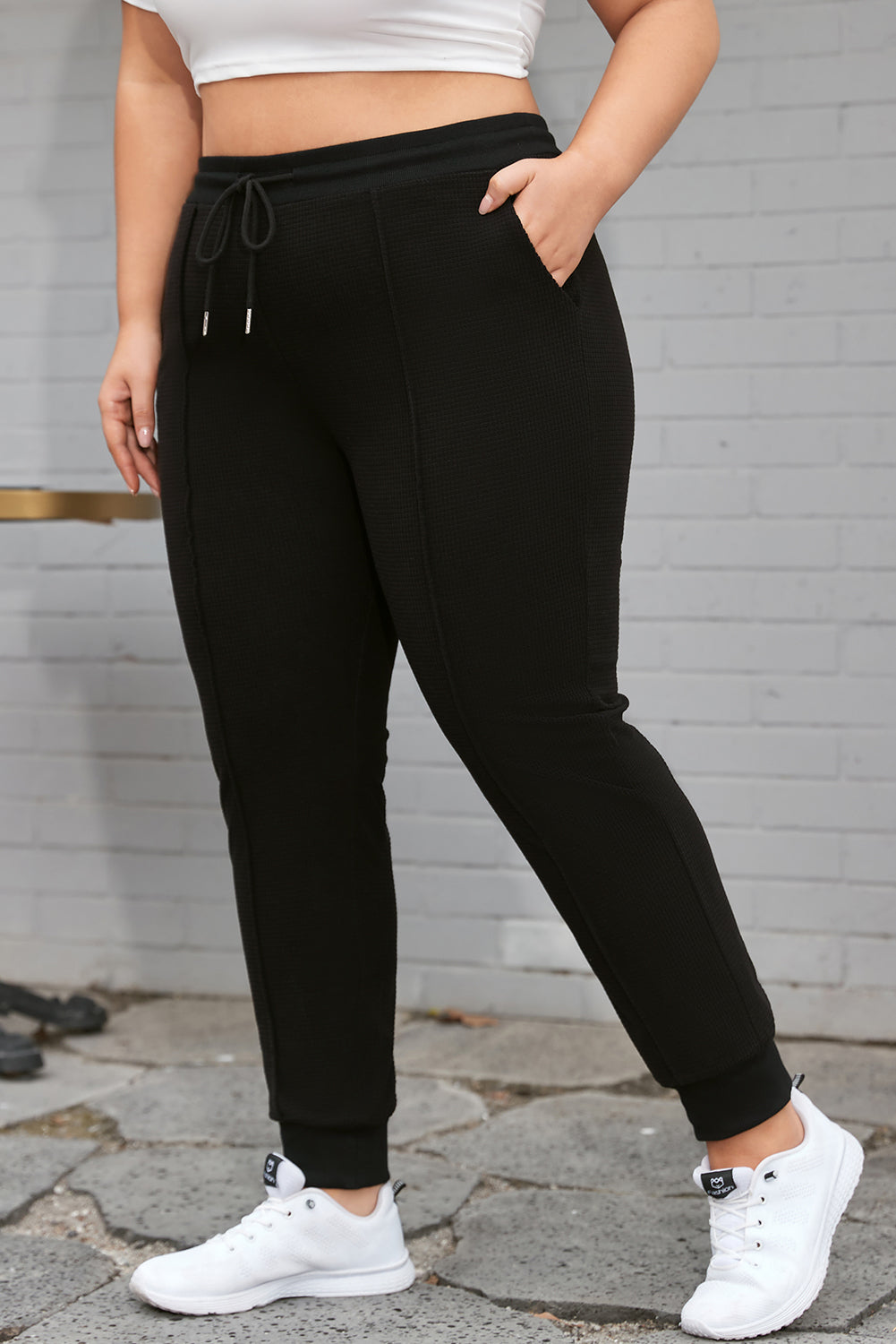 Črne jogger hlače z razkritimi šivi in ​​vrvicami velike velikosti
