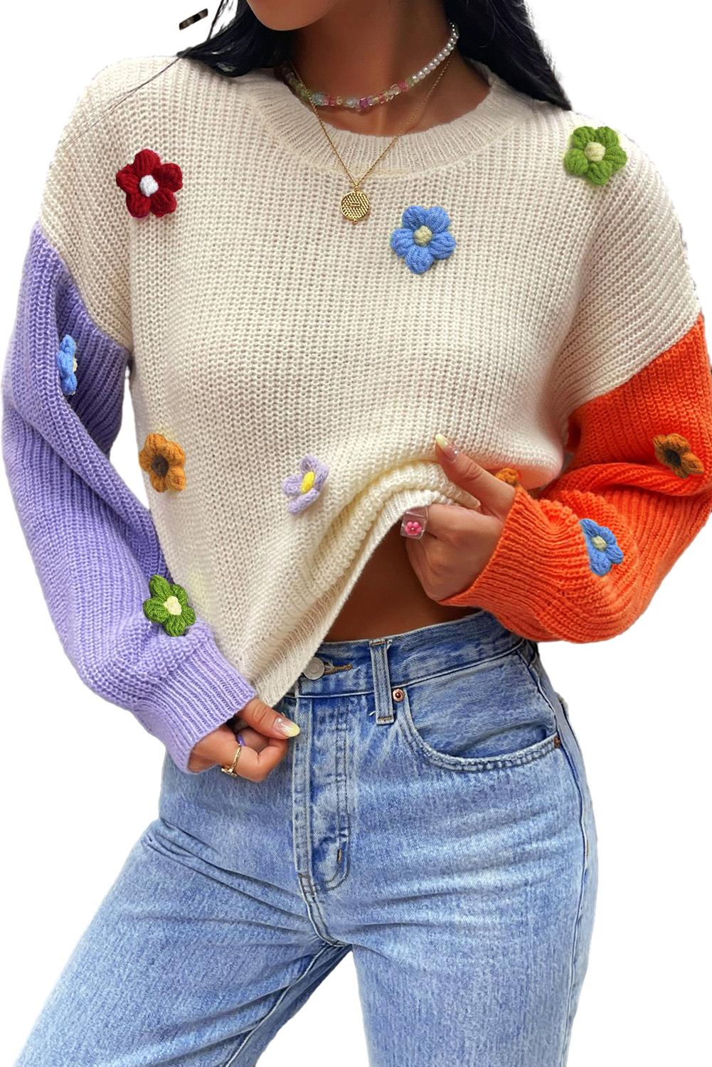 Pulover z večbarvnimi cvetličnimi aplikacijami in barvnimi bloki na spuščena ramena