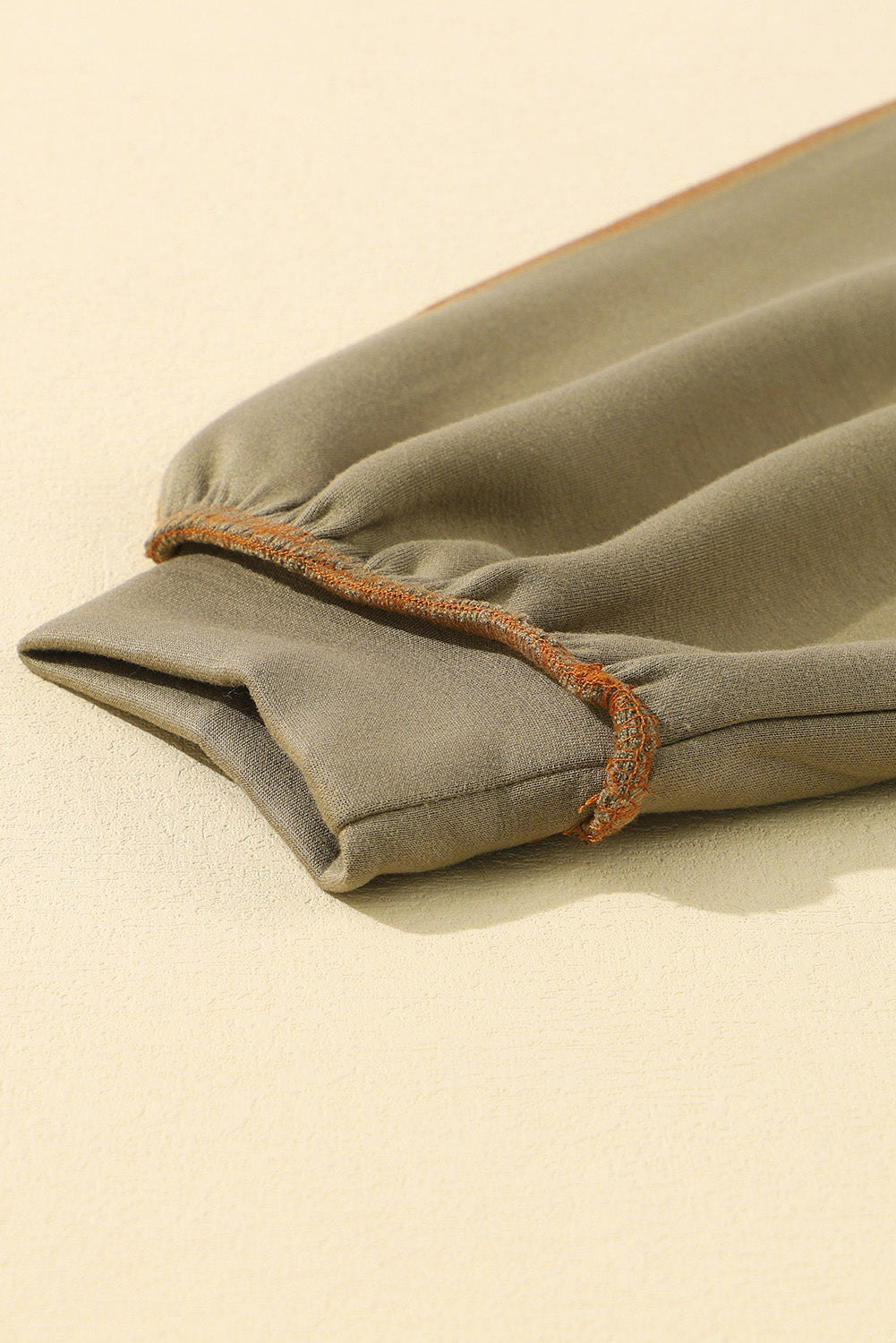 Pulover z zadrgo v kaki barvi z izpostavljenimi šivi