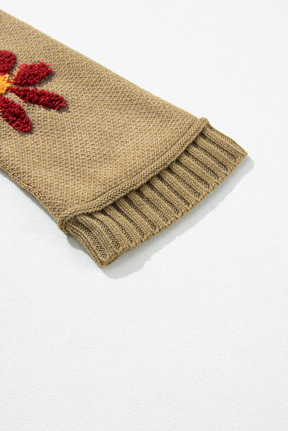 Pleten pulover z rebrastim v-izrezom in zelenimi cvetovi