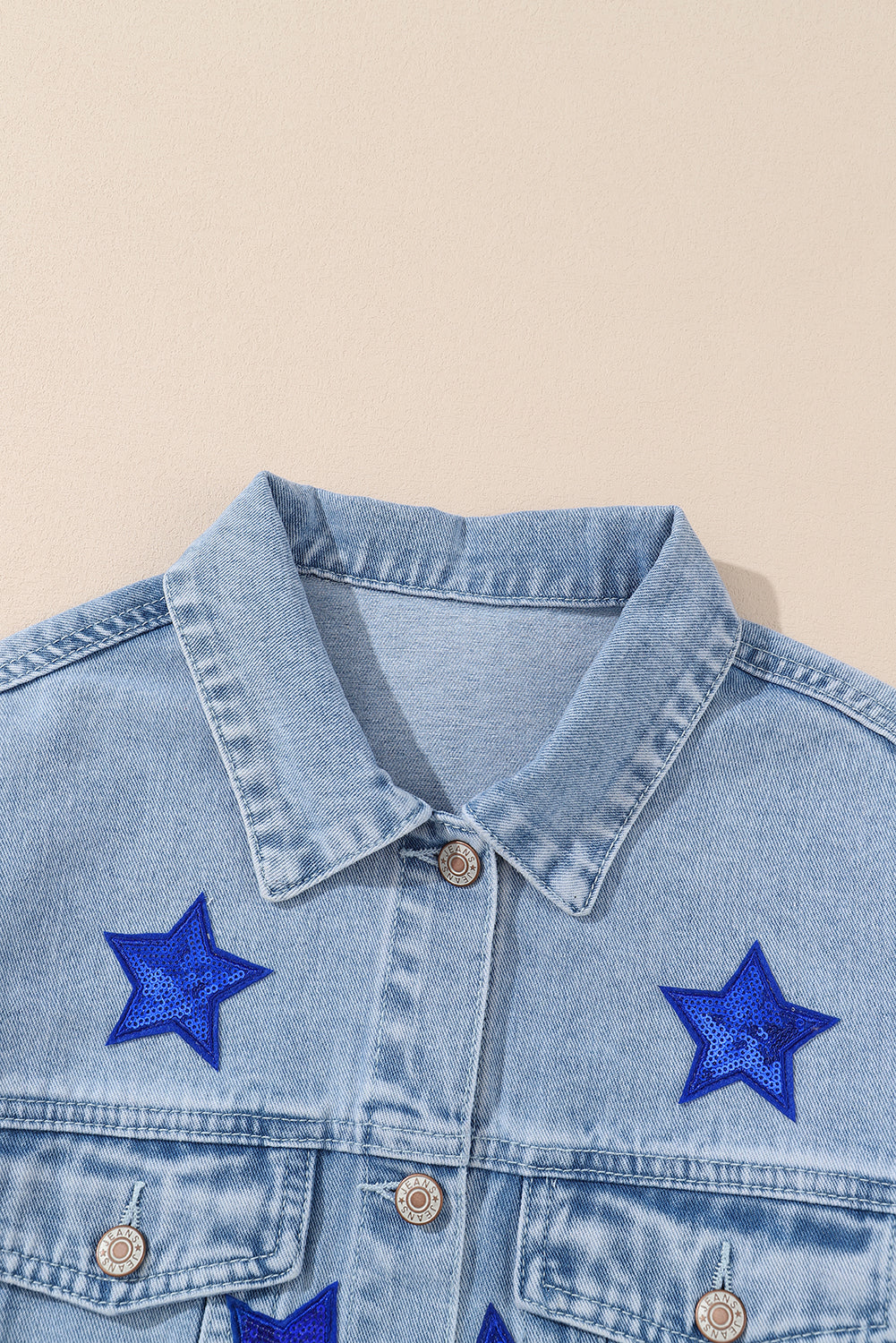 Bläuliche Jeansjacke mit Sternen und Pattentaschen und Pailletten