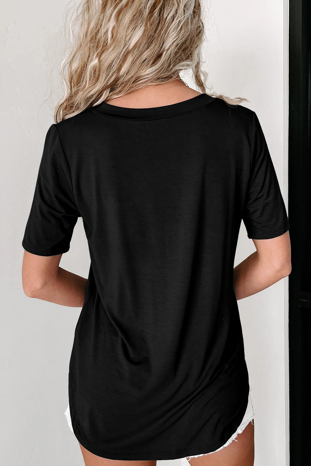 Črna majica z zaobljenim robom in žepki v izrezu