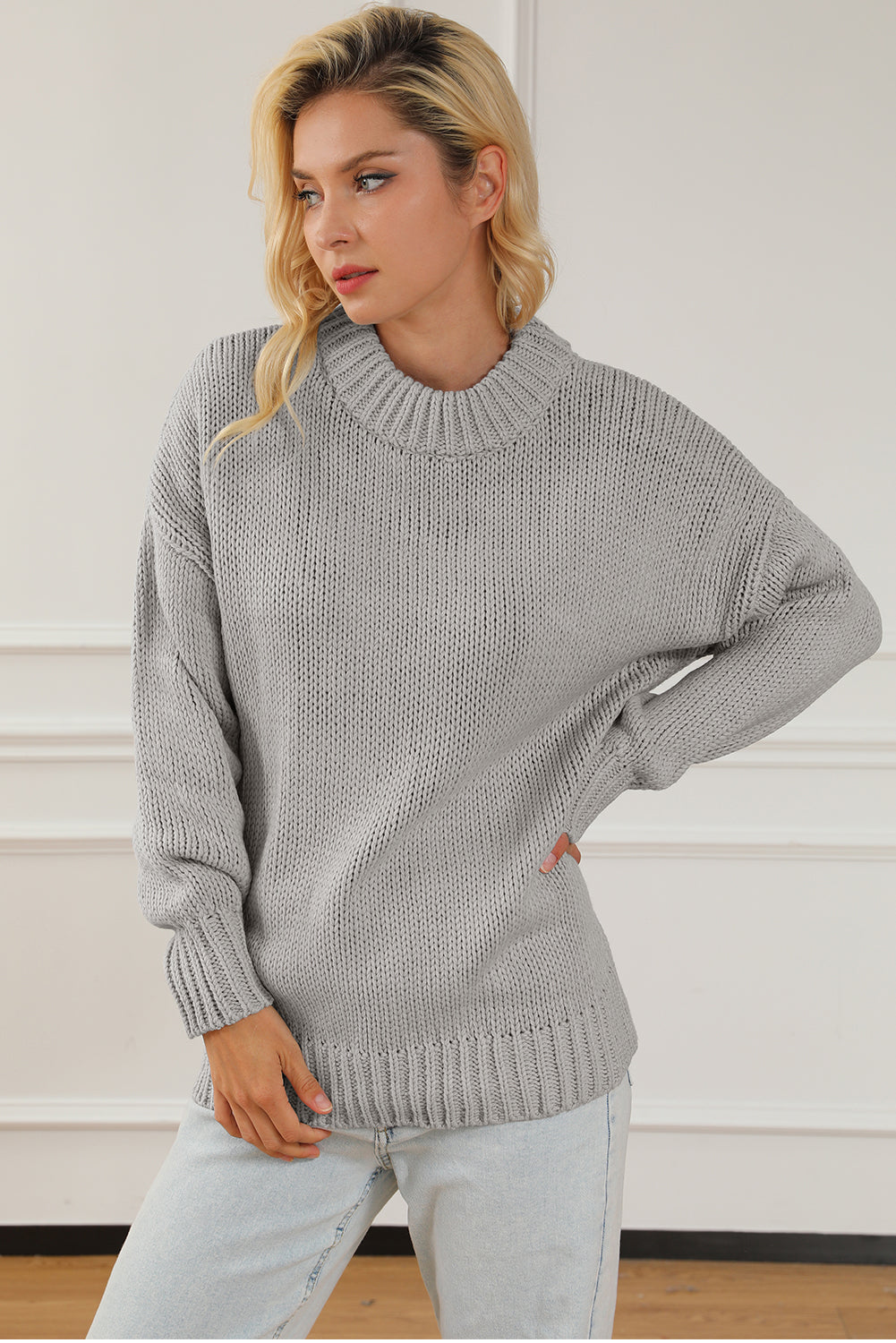 Svijetlosivi pulover s dugim ramenima i krupnim pletenim ovratnikom