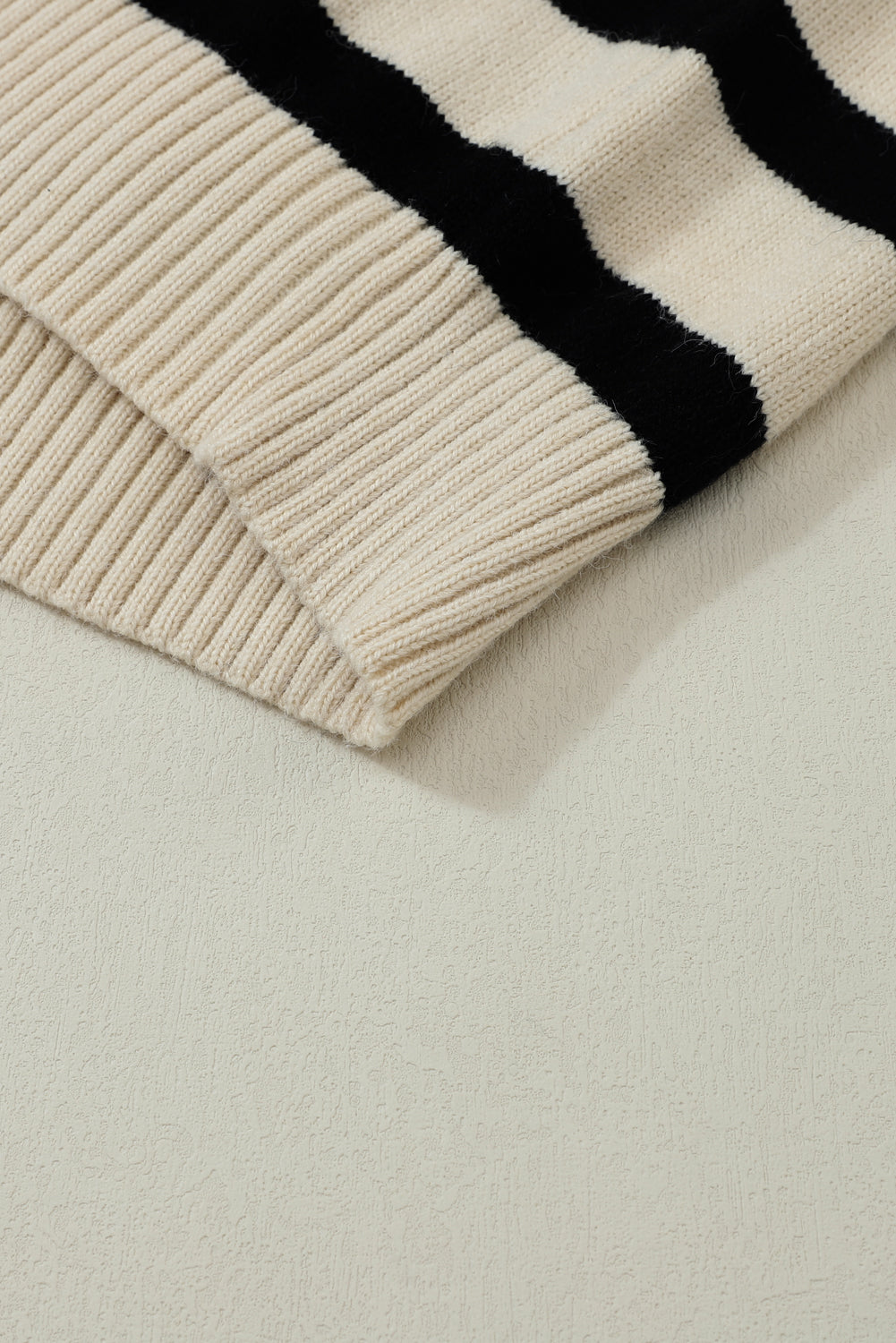 Prugasti pleteni pulover spuštenih ramena i V izrezom boje marelice