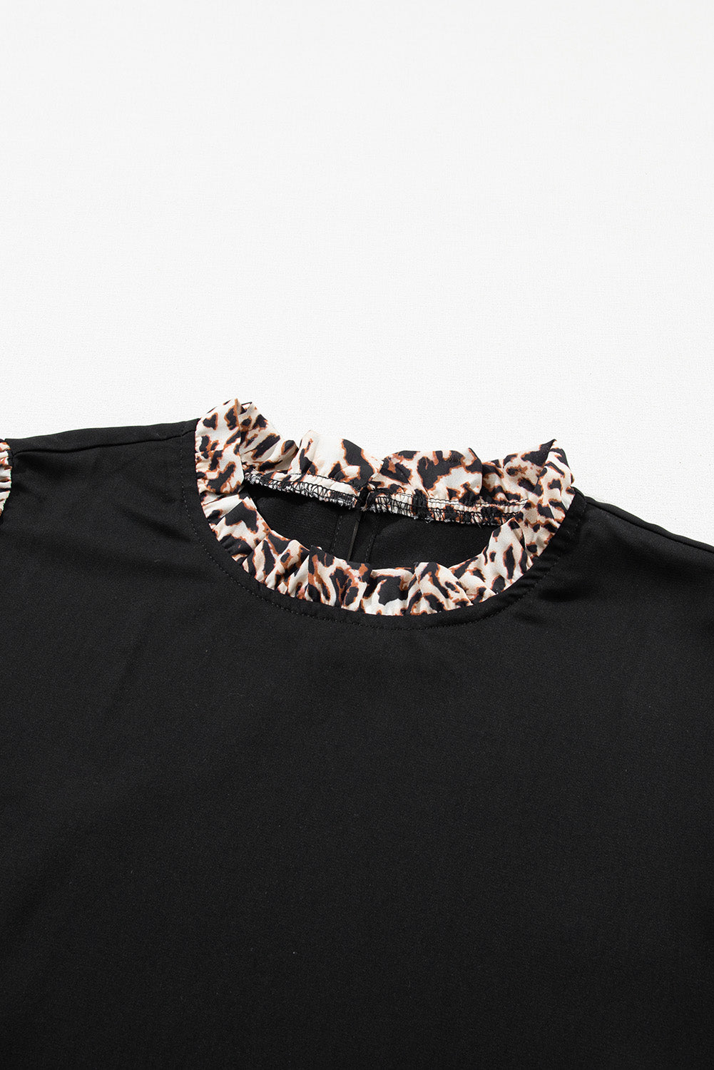 Blouse noire à manches lanternes et imprimé léopard contrasté